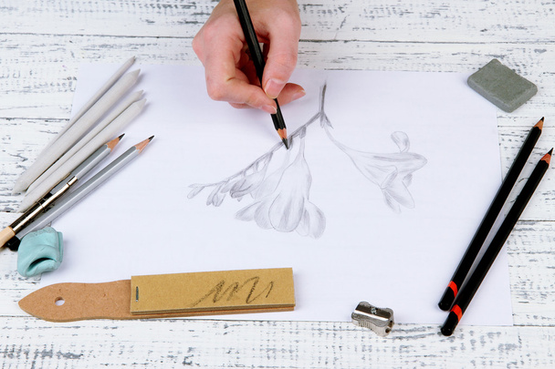 Hand draws a sketch with professional art materials, on wooden table - Fotó, kép