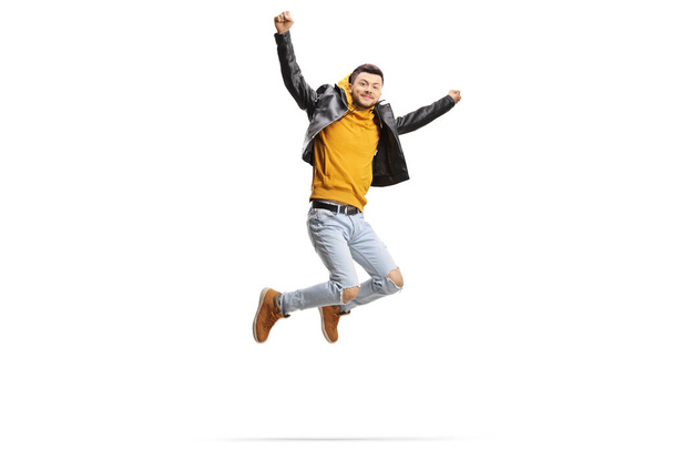 Trendy cool guy jumping and raising arms isolated on white background - Photo, image