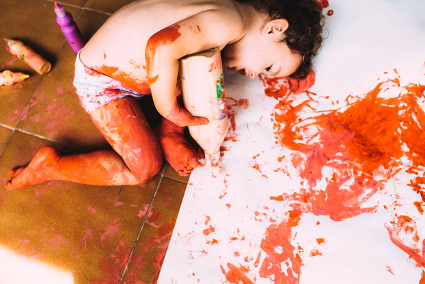 Однорічна дівчинка любить бруднитися фарбою і робити безлад з нею
. - Фото, зображення