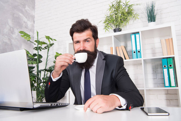 First thing in the morning. Bearded man drink morning coffee in office. Manager enjoy hot drink in morning. Breakfast tea. Ultimate morning routine - Photo, image