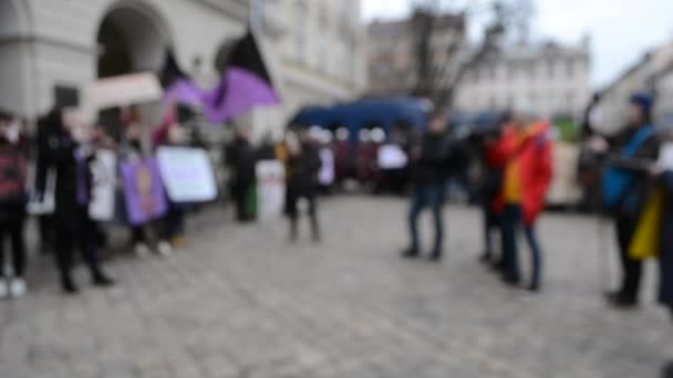 Люди стоят на площади в знак протеста против размытого фона
. - Кадры, видео