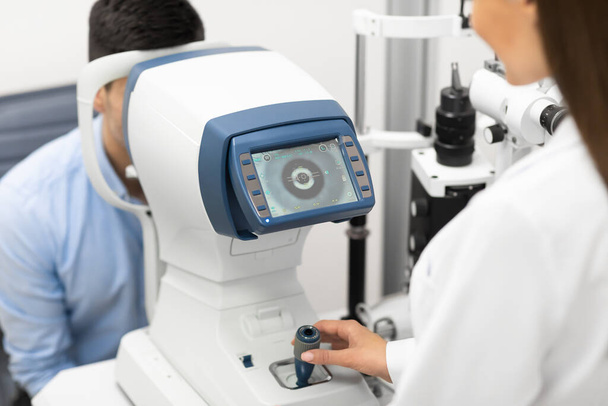 Оптометрист перевіряє зір пацієнтів у сучасній клініці
 - Фото, зображення