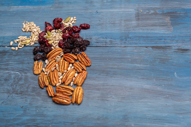 Ořechy ve tvaru lidského srdce s vlašskými ořechy, rozinkami, dýňovými semínky, sušenými brusinkami - Fotografie, Obrázek