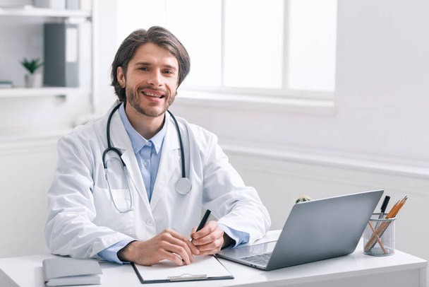 Arzt sitzt am Arbeitsplatz im Büro - Foto, Bild