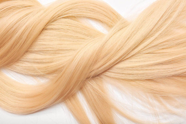 Красиве довге світле волосся на білому тлі, крупним планом
 - Фото, зображення