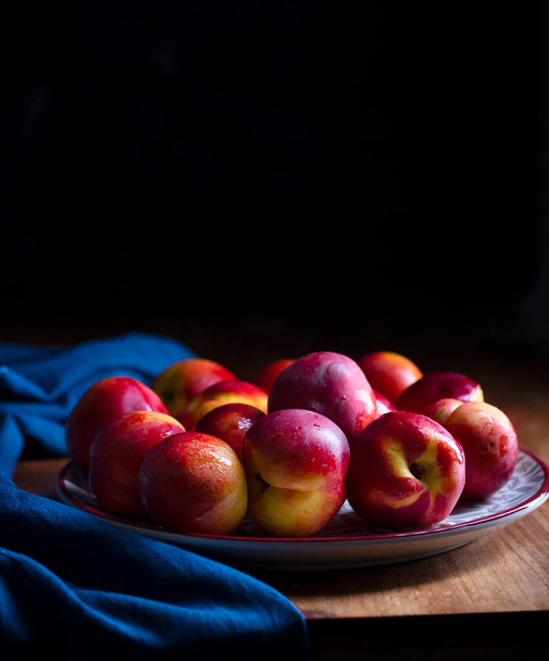 A group of colorful nectarine fruits or peach on a plate - Fotoğraf, Görsel