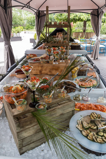 Luxury catering by the pool, food bloggers event, banquet, wedding, festive, hotel brunch buffet arrangement with clean simple design, decorations, boat filled with ice. Modern design and decorations - Fotografie, Obrázek