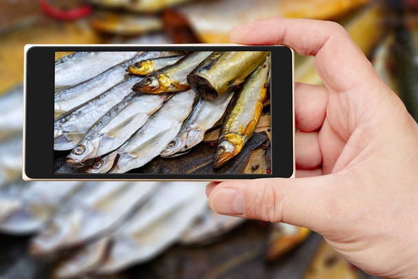 Akıllı telefon ekranında füme balık. Deniz ürünleri satışı. Mağaza vitrininde balık. - Fotoğraf, Görsel