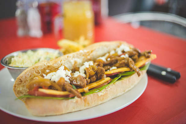 Close up image of a gourmet hotdog being served in a diner - Foto, afbeelding