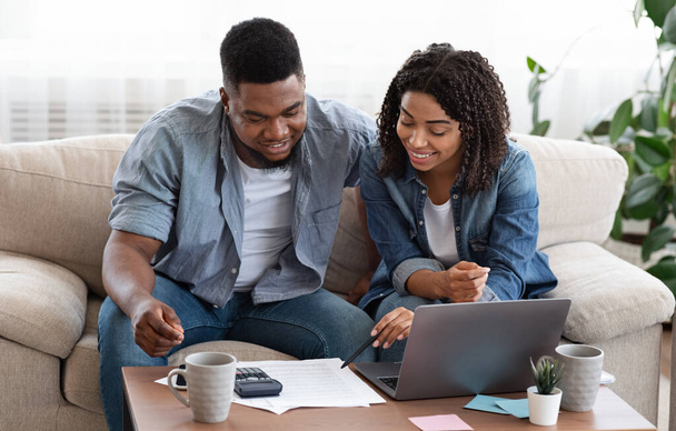 Young african spouses managing their family budget together at home - Photo, Image