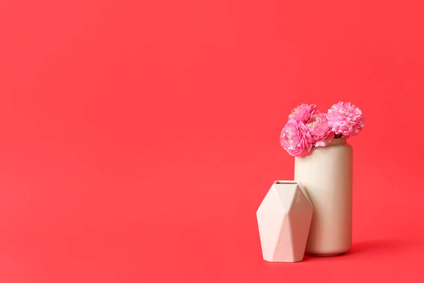 Different vases with bouquet of flowers on color background - Foto, afbeelding