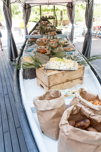 Luxury catering by the pool, food bloggers event, banquet, wedding, festive, hotel brunch buffet arrangement with clean simple design, decorations, boat filled with ice. Modern design and decorations - 写真・画像
