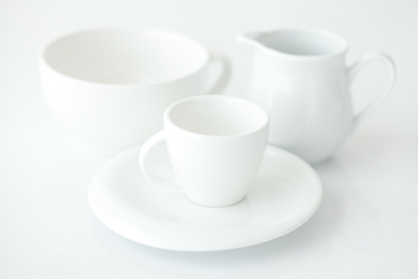 white cup with saucer and milk jug - Fotó, kép