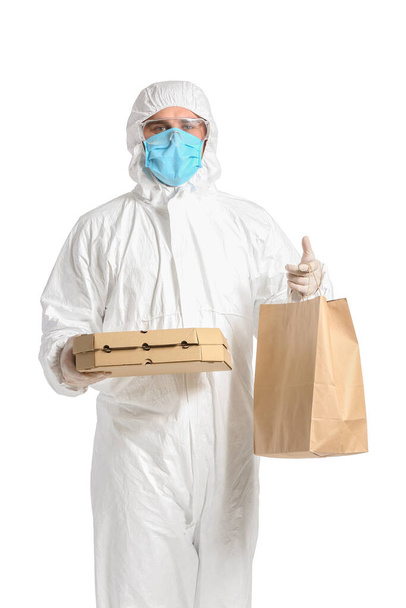 Courier of food delivery service in protective suit on white background. Concept of epidemic - Fotó, kép