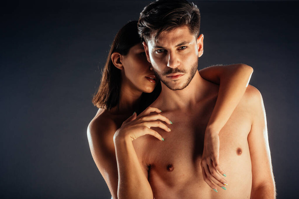Half naked pair of male and female models gently touching and cuddling - Photo, Image