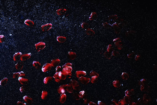 Water drops on ripe sweet pomegranate seeds. Fresh pomegranate background with copy space for your text. Vegan and vegetarian concept. - Φωτογραφία, εικόνα