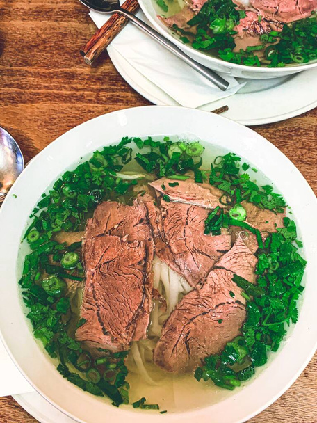 A vertical shot of noodle soup with beef and vegetables - Photo, image