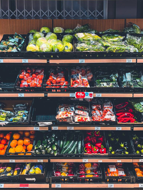 A vertical shot of a market shelves full of with different vegetables and fruits - Foto, imagen