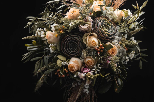 A closeup shot of a luxurious bouquet of orange and brown roses on a black background - Fotoğraf, Görsel