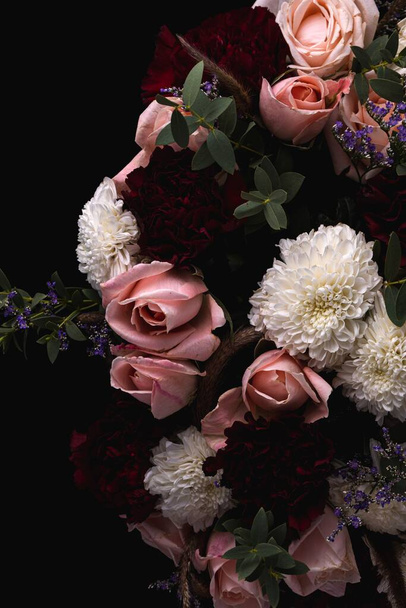A vertical shot of a luxurious bouquet of pink and red roses and white dahlias on a black background - Foto, immagini