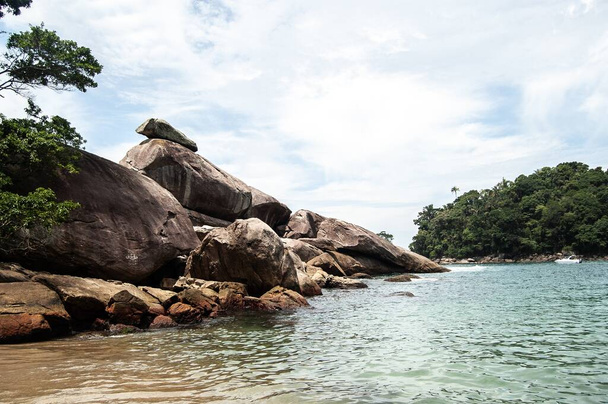 A beautiful shot of a seashore with forested mountains in Ilha Grande, Brazil - Фото, изображение