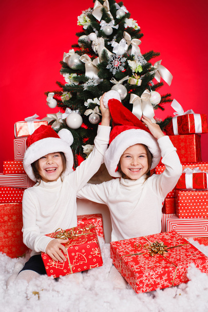 Happy teen sisters decorating Christmas tree - 写真・画像