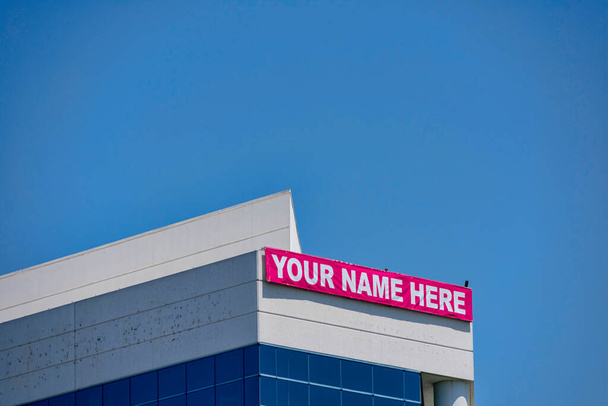 Ihr Name hier - großes Banner auf einem leer stehenden Geschäftshaus, das für Immobilien, Immobilien, Büros zum Verkauf, zur Miete oder zur Vermietung wirbt. - Foto, Bild