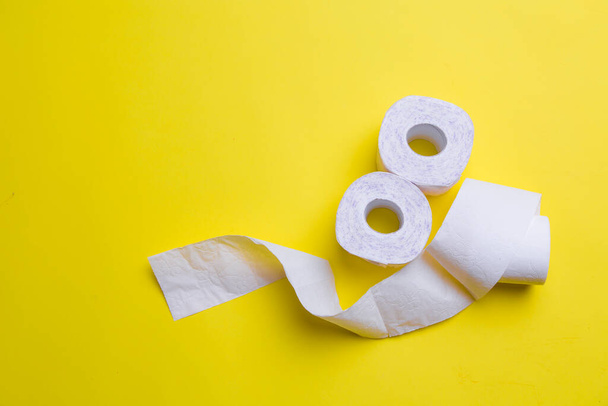 toilet paper rolls on yellow background. everyday objects in copy space. shortage of raw materials during period of coronavirus. a popular product on market. delivery of goods for house - Foto, Imagen