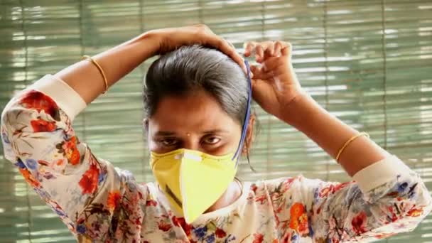 Primer plano de una mujer india que muestra cómo usar una máscara N95 de seguridad y protección ocular correctamente para protegerse del Coronovirus Covid19
 - Imágenes, Vídeo
