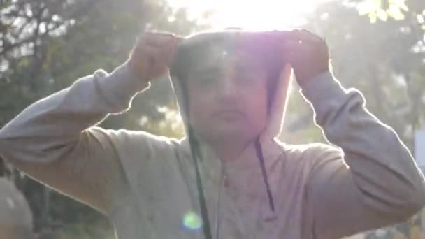 close-up van een volwassen aziatische man het dragen van een hoodie sweater en joggen tijdens dageraad - Video