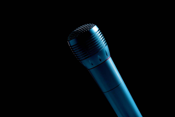 microfono audio su un supporto in uno sfondo nero scuro, retroilluminazione blu
 - Foto, immagini