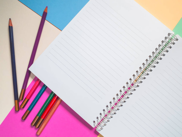 Notebook on a color background and color pencil collection - 写真・画像