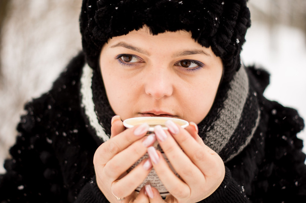 woman with cup of coffee in the winter park - Photo, Image