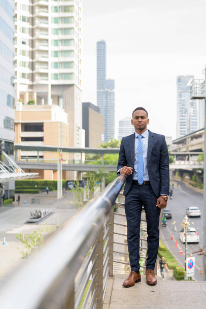 Retrato de un joven hombre de negocios africano guapo usando traje en las calles de la ciudad al aire libre
 - Foto, imagen