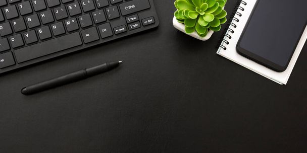 Black desk office with laptop, smartphone and other work supplies with cup of coffee. Top view with copy space for input the text. Designer workspace on desk table essential elements on flat lay - Photo, image