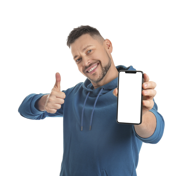 Όμορφος άνθρωπος με κινητό τηλέφωνο δείχνει αντίχειρα-up σε λευκό φόντο - Φωτογραφία, εικόνα
