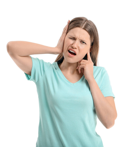 Young woman suffering from loud noise on white background - Photo, Image