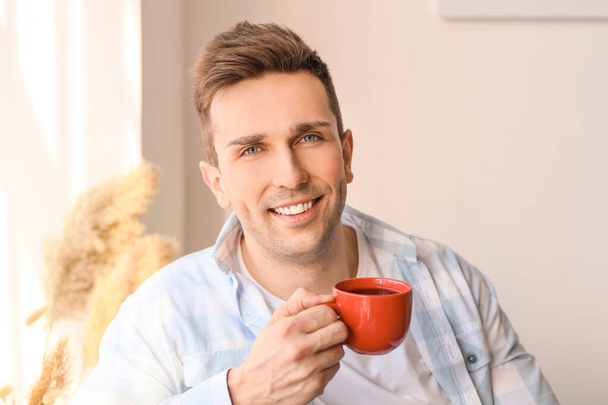 Handsome man drinking coffee at home - Fotoğraf, Görsel