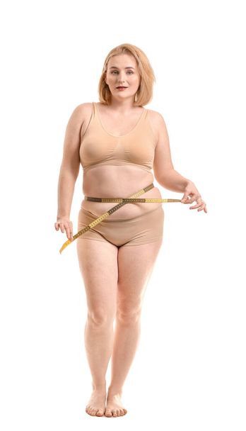 Femme en surpoids avec ruban à mesurer sur fond blanc. Concept de perte de poids
 - Photo, image