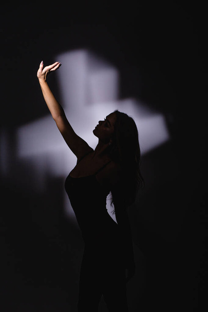 Girl dancer, flexible plastic, dancing in a jump. spotlight, hand shadow. - Foto, imagen