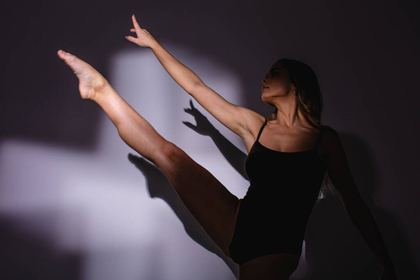 Girl dancer, flexible plastic, dancing in a jump. spotlight, hand shadow. - Foto, Imagem