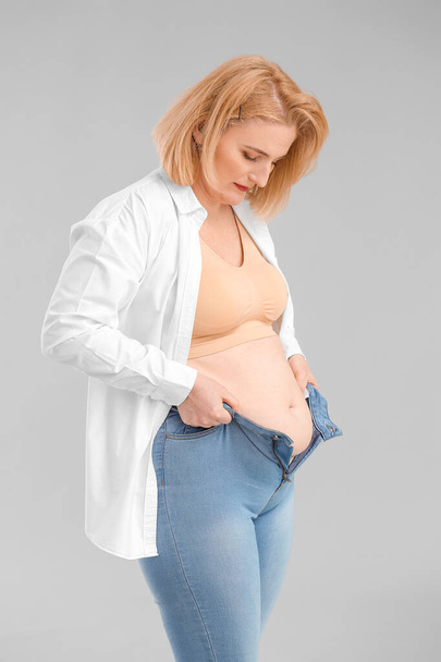 vrouw met overgewicht op grijze achtergrond - Foto, afbeelding