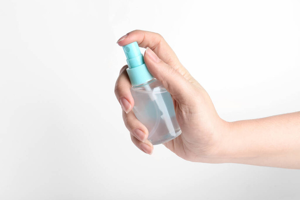 Woman holding antiseptic spray on white background, closeup - Фото, изображение