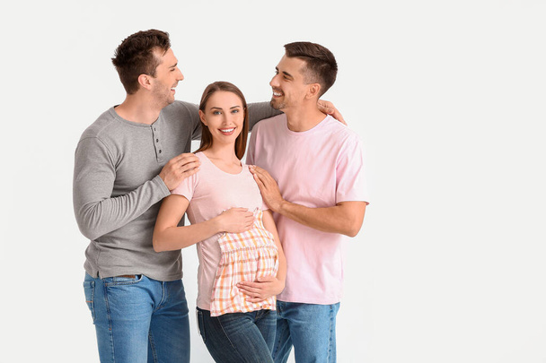 Gay couple with pregnant woman on white background - Fotó, kép
