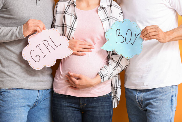 gay casal e grávida mulher com escrito palavras gIRL um menino, close-up
 - Foto, Imagem