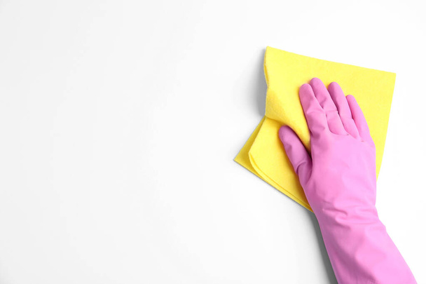 Person in rubber glove with rag on white background, closeup of hand - Fotografie, Obrázek