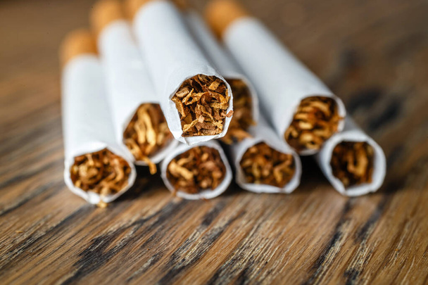 Ahşap arka planda sigara içilen el yapımı bir sigarayı kapat - Fotoğraf, Görsel
