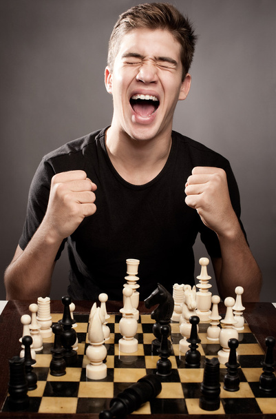 Young man celebrating chess win - Foto, imagen