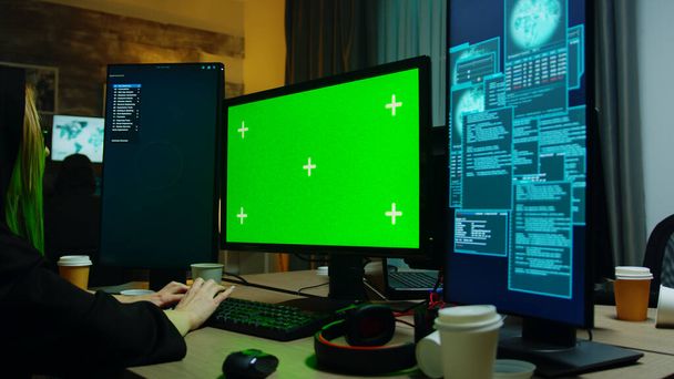 Zoom en la toma de la chica hacker en frente de la computadora con pantalla verde
 - Foto, Imagen