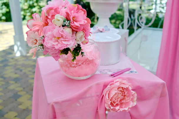 Bouquet of white and pink flowers in vintage vase on table outdoors, free space. Wedding floral decoration. Beautiful set up for wedding ceremony - Photo, image